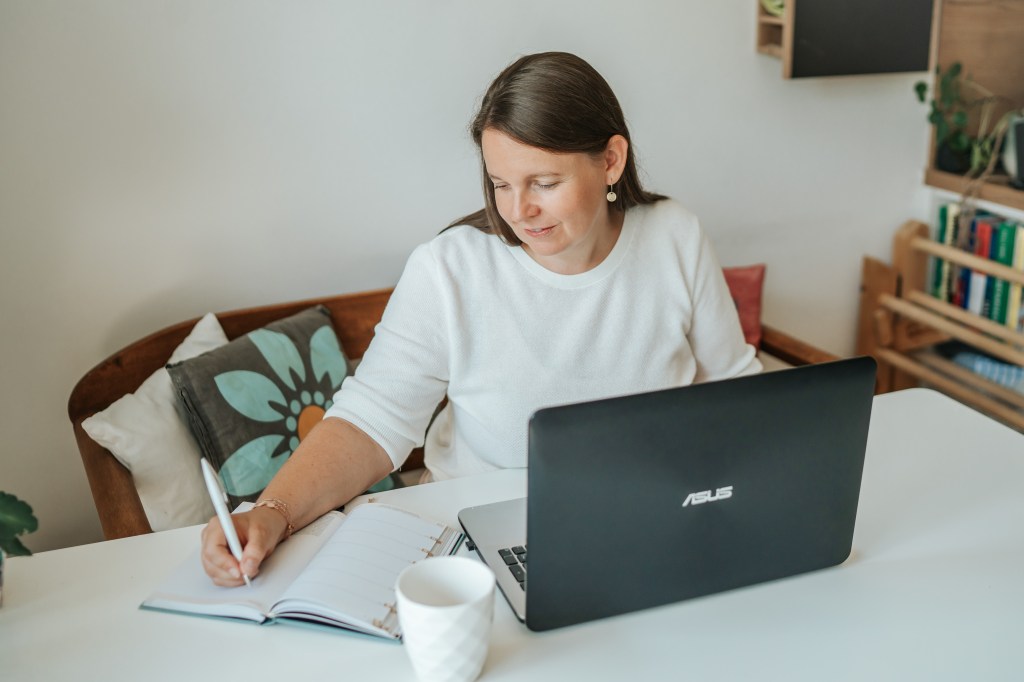 Frau trägt Termine in den Kalender ein